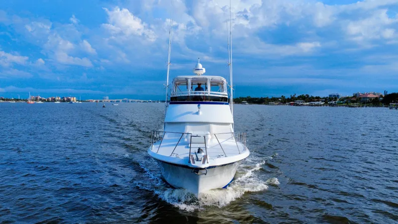 Reel Amnesia Yacht Photos Pics 1984 Hatteras 36 Convertible yacht cruising on open water under a blue sky.