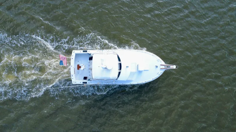 Reel Amnesia Yacht Photos Pics Aerial view of 1984 Hatteras 36 Convertible boat cruising on water.