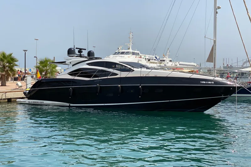  Yacht Photos Pics 2010 Sunseeker Predator 64 yacht docked in a marina, sleek black design.