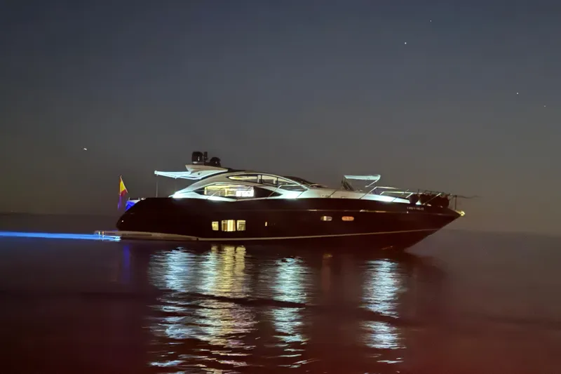  Yacht Photos Pics Luxurious 2010 Sunseeker Predator 64 yacht illuminated at night on calm waters.