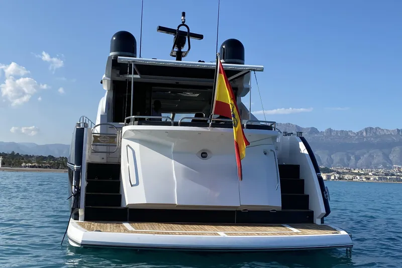 Yacht Photos Pics 2010 Sunseeker Predator 64 yacht on calm water, Spanish flag, mountain backdrop.