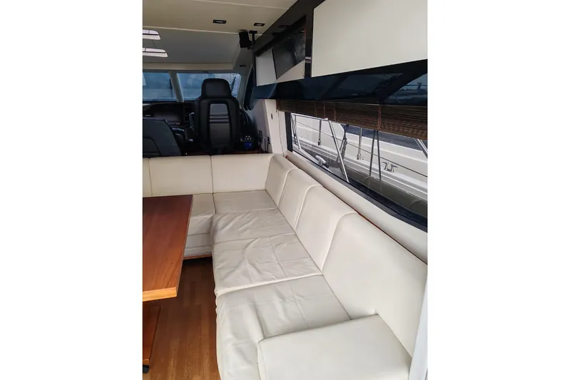  Yacht Photos Pics Interior of 2010 Sunseeker Predator 64 yacht with white leather seating and wooden table.