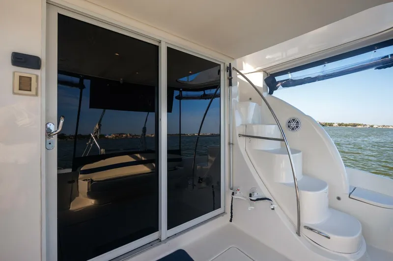Why Knot Yacht Photos Pics 2010 Meridian 391 Sedan yacht with sleek glass doors and curved staircase by the water.