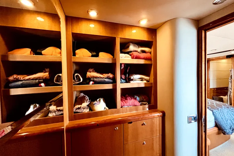  Yacht Photos Pics Luxurious wooden closet with neatly arranged clothes on a 2005 Sunseeker 75 Sport Yacht.