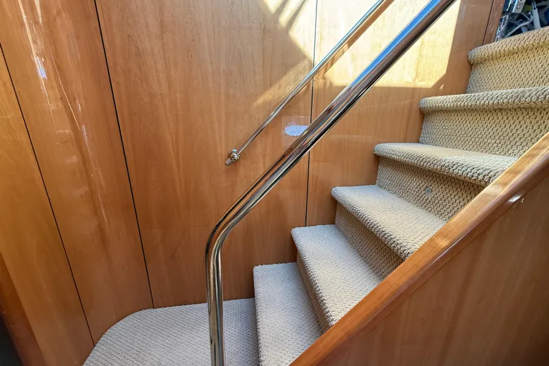  Yacht Photos Pics Carpeted stairs with wooden paneling and metal railing on a 2005 Sunseeker 75 Sport Yacht.
