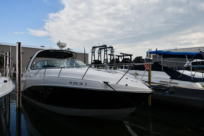 Yacht Photos Pics 2014 Rinker 310 Express Cruiser docked at marina under cloudy sky.
