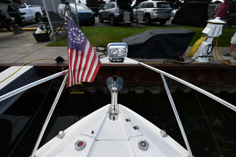  Yacht Photos Pics 2014 Rinker 310 Express Cruiser bow with American flag at dockside.