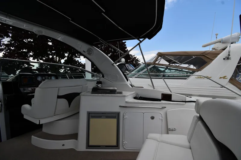  Yacht Photos Pics 2014 Rinker 310 Express Cruiser interior with seating and dashboard, under a canopy.