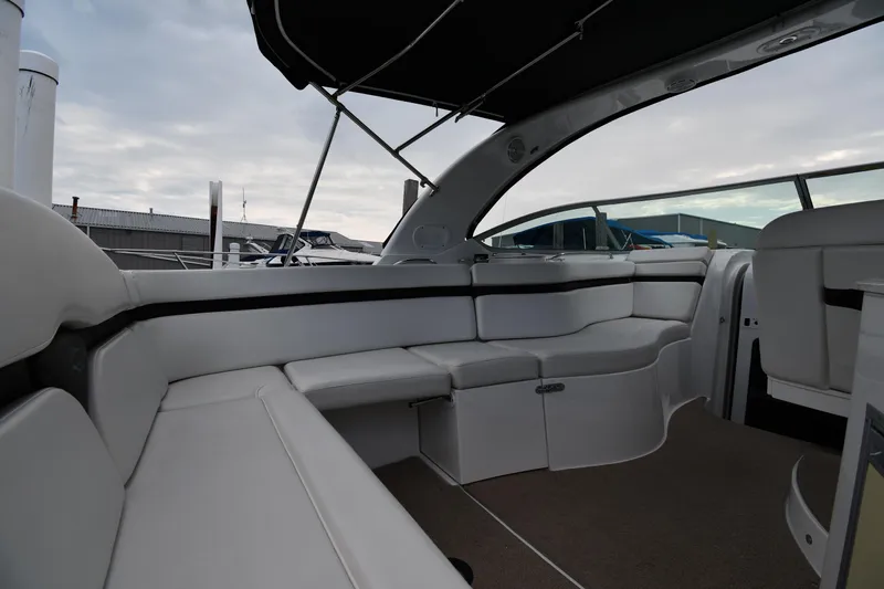  Yacht Photos Pics 2014 Rinker 310 Express Cruiser interior with white seating and canopy, docked at marina.