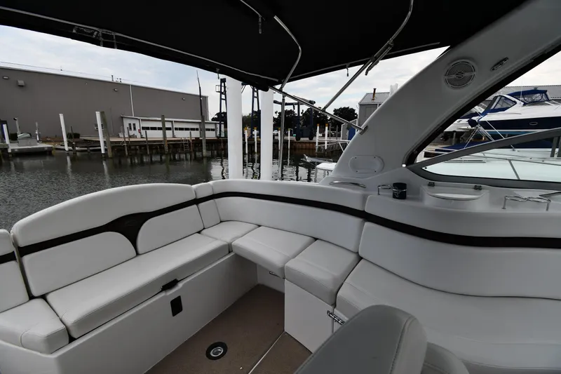  Yacht Photos Pics 2014 Rinker 310 Express Cruiser interior with white seating, docked at marina.