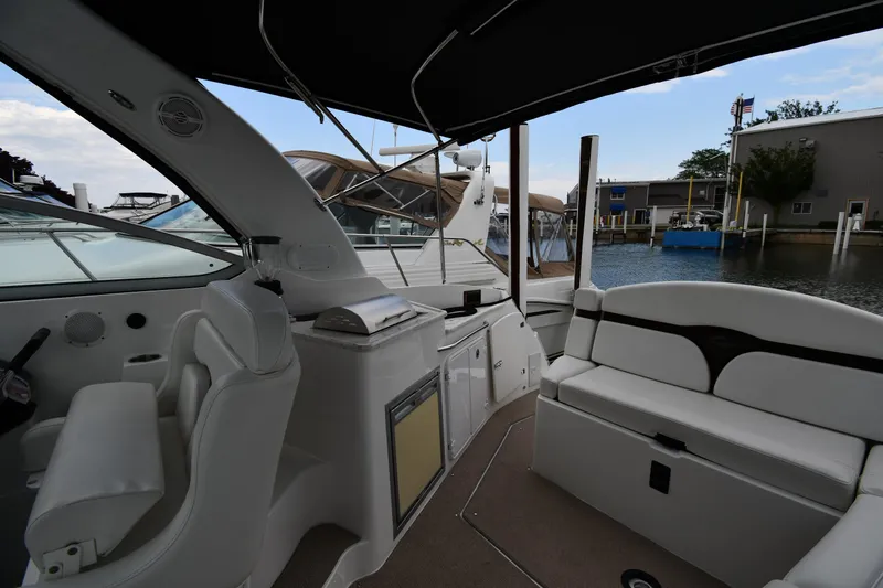  Yacht Photos Pics 2014 Rinker 310 Express Cruiser interior with seating and helm, docked at marina.