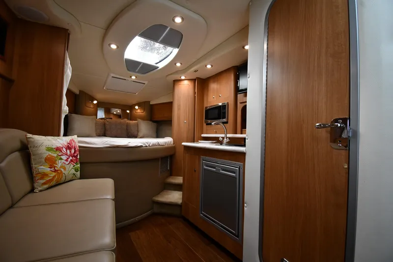  Yacht Photos Pics 2014 Rinker 310 Express Cruiser interior with cozy seating, kitchenette, and bed.