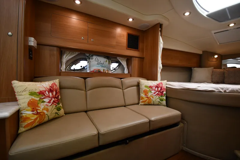  Yacht Photos Pics Interior of 2014 Rinker 310 Express Cruiser with beige sofa and floral pillows.