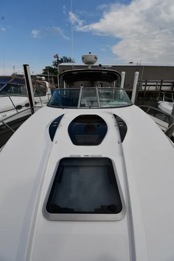  Yacht Photos Pics 2014 Rinker 310 Express Cruiser boat docked under a partly cloudy sky.
