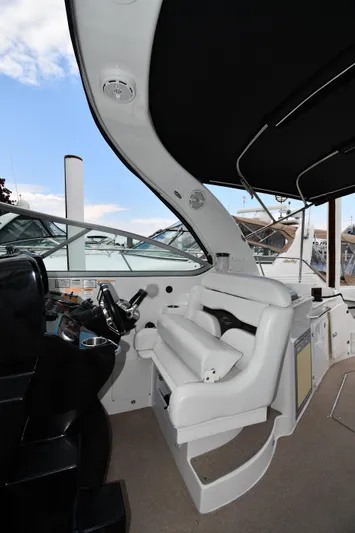  Yacht Photos Pics 2014 Rinker 310 Express Cruiser helm with white seating and black canopy.
