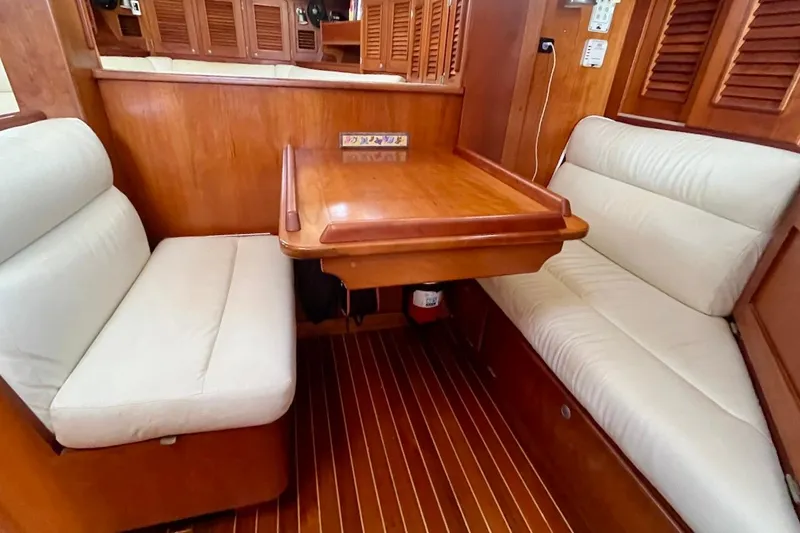  Yacht Photos Pics Cozy dining area in 1997 Gozzard 44 yacht with wooden table and cushioned seating.