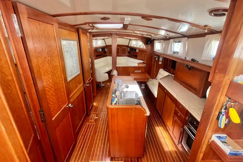  Yacht Photos Pics Interior of 1997 Gozzard 44 sailboat with wooden cabinetry and cozy seating area.