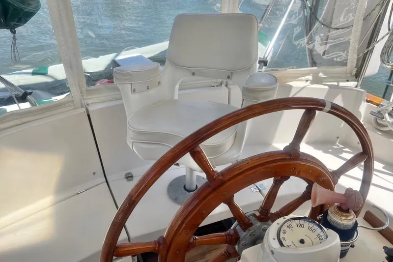  Yacht Photos Pics Cockpit of 1997 Gozzard 44 sailboat with wooden wheel and white captain's chair.
