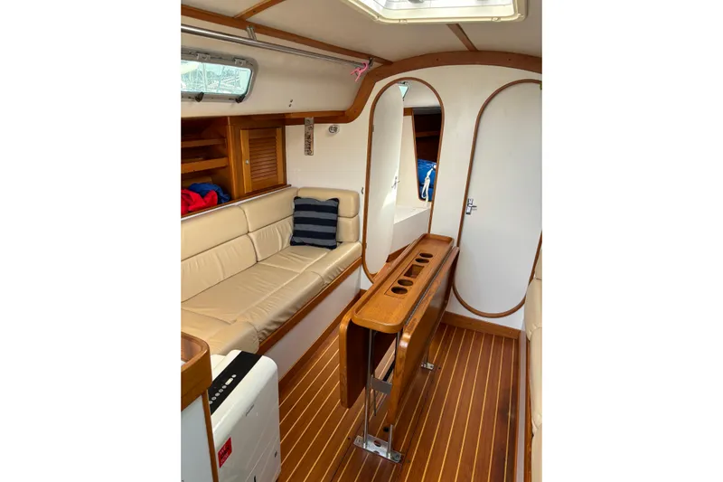 Jane Yacht Photos Pics Interior of 2002 J Boats J/120 sailboat with wooden flooring and beige seating.