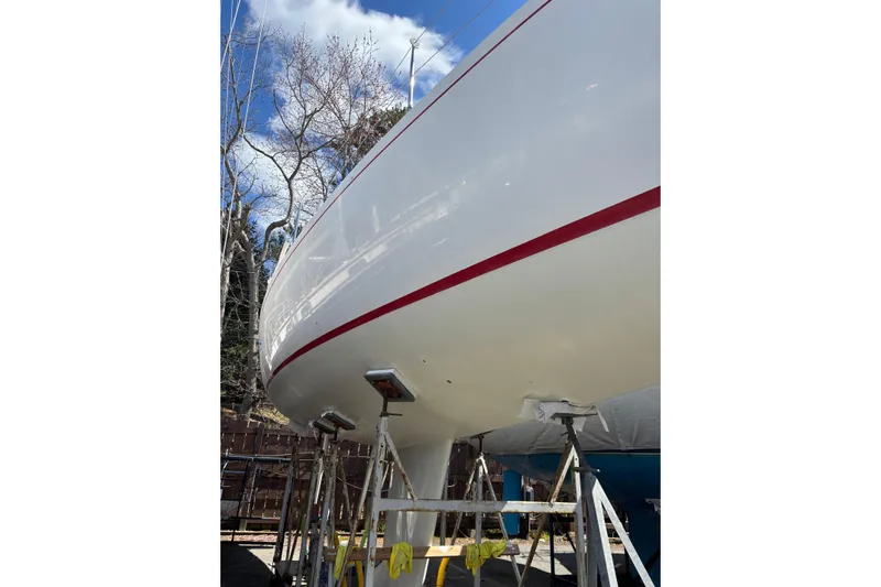 Jane Yacht Photos Pics 2002 J Boats J/120 sailboat on stands, under clear blue sky.