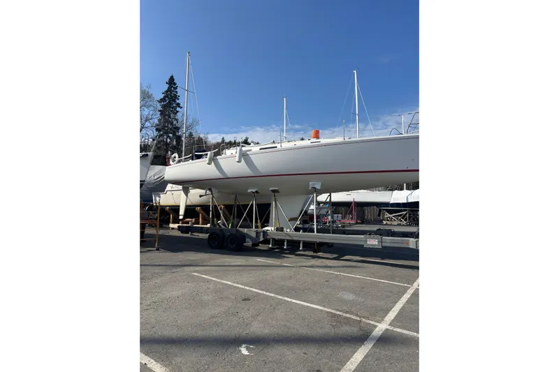 Jane Yacht Photos Pics 2002 J Boats J/120 sailboat on trailer in parking lot under clear sky.