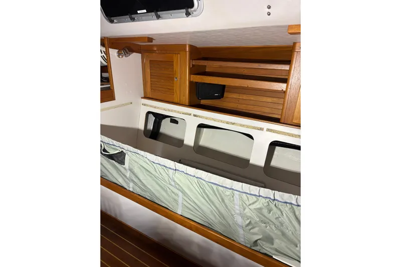 Jane Yacht Photos Pics Interior of 2002 J Boats J/120 sailboat with wooden cabinetry and storage shelves.