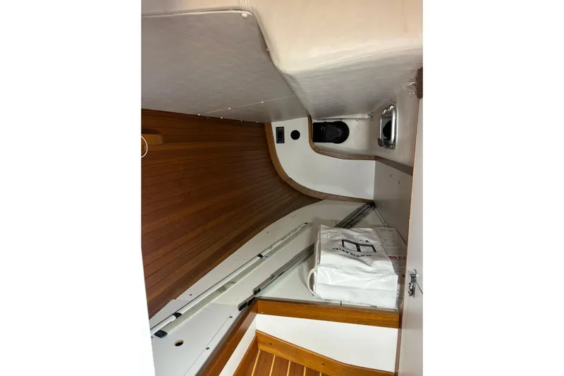 Jane Yacht Photos Pics Interior of 2002 J Boats J/120 sailboat with wooden paneling and storage area.