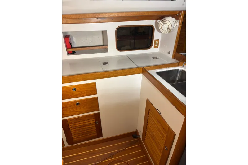 Jane Yacht Photos Pics Interior of 2002 J Boats J/120, featuring wooden cabinetry and compact kitchen area.