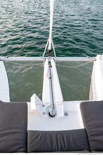 Martina Yacht Photos Pics 2021 Lagoon 46 catamaran deck with netting over ocean water.