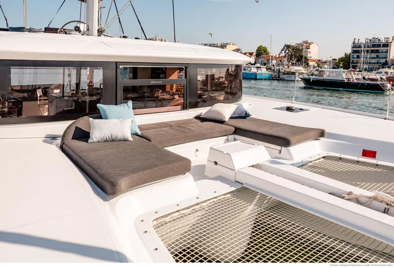 Martina Yacht Photos Pics Luxurious 2021 Lagoon 46 catamaran with spacious deck and comfortable seating in a marina.