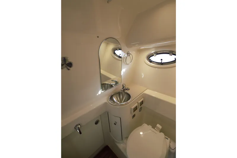 Finn Yacht Photos Pics 2006 Tiara Yachts 3000 Open bathroom with sink, mirror, and porthole window.