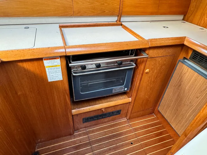 Heeling Alright Yacht Photos Pics 2001 Jeanneau Sun Odyssey 40 yacht kitchen with wooden cabinetry and built-in oven.