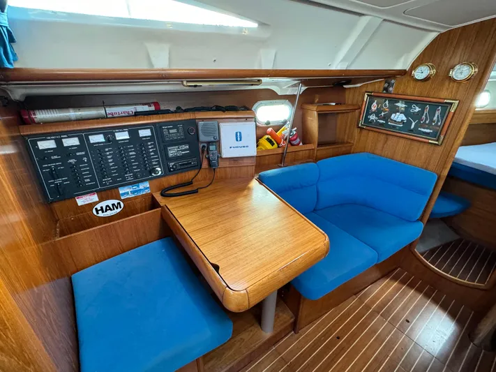 Heeling Alright Yacht Photos Pics Interior of 2001 Jeanneau Sun Odyssey 40 sailboat with blue seating and wooden table.