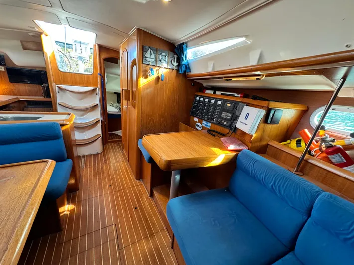 Heeling Alright Yacht Photos Pics Interior of 2001 Jeanneau Sun Odyssey 40 sailboat with wood finish and blue seating.