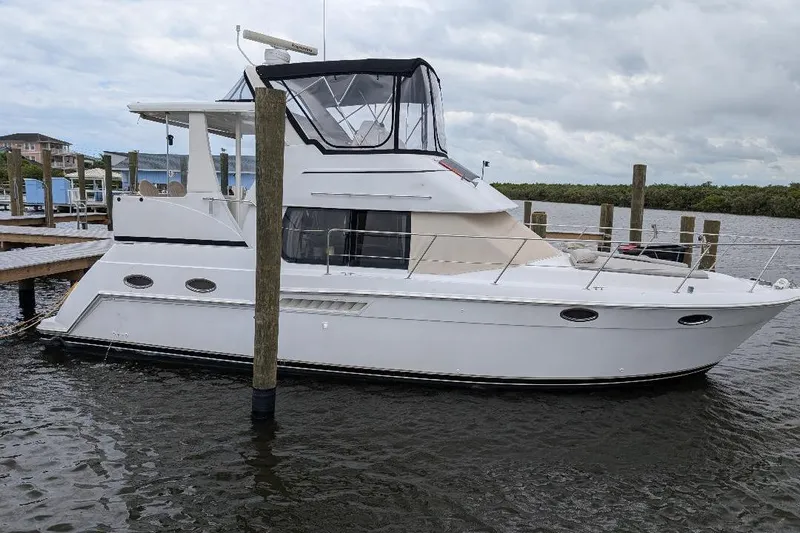 This New Interior Is Amazing! Yacht Photos Pics 2003 Carver 356 Motor Yacht docked at a marina under cloudy skies.
