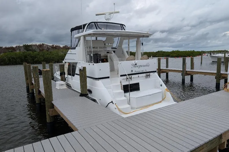This New Interior Is Amazing! Yacht Photos Pics 2003 Carver 356 Motor Yacht docked at marina under cloudy skies.