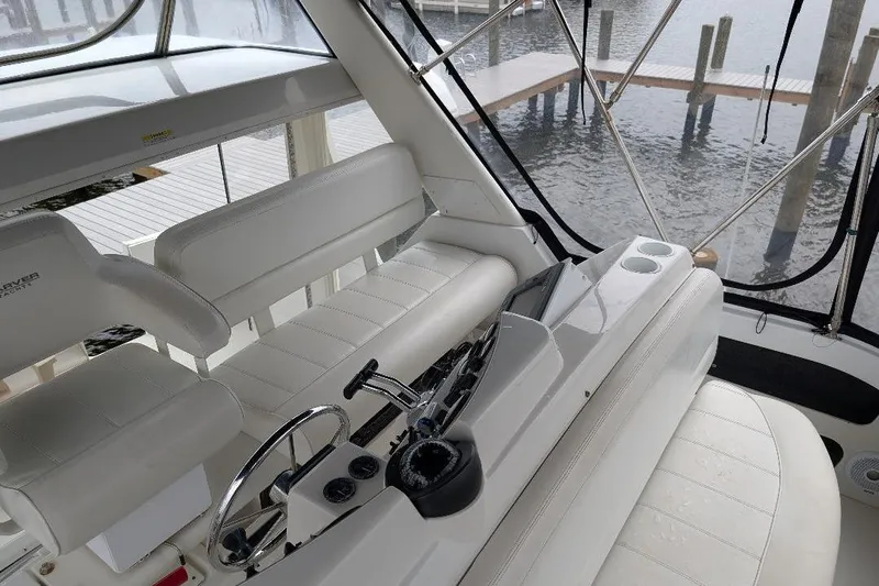 This New Interior Is Amazing! Yacht Photos Pics 2003 Carver 356 Motor Yacht interior with white seating and control panel, dockside view.