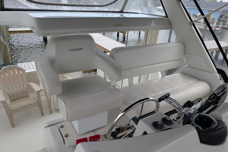 This New Interior Is Amazing! Yacht Photos Pics 2003 Carver 356 Motor Yacht helm with white seating and steering wheel.