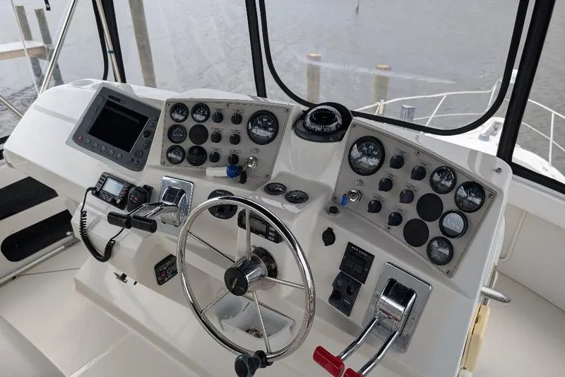 This New Interior Is Amazing! Yacht Photos Pics Helm of 2003 Carver 356 Motor Yacht with steering wheel and control panel.