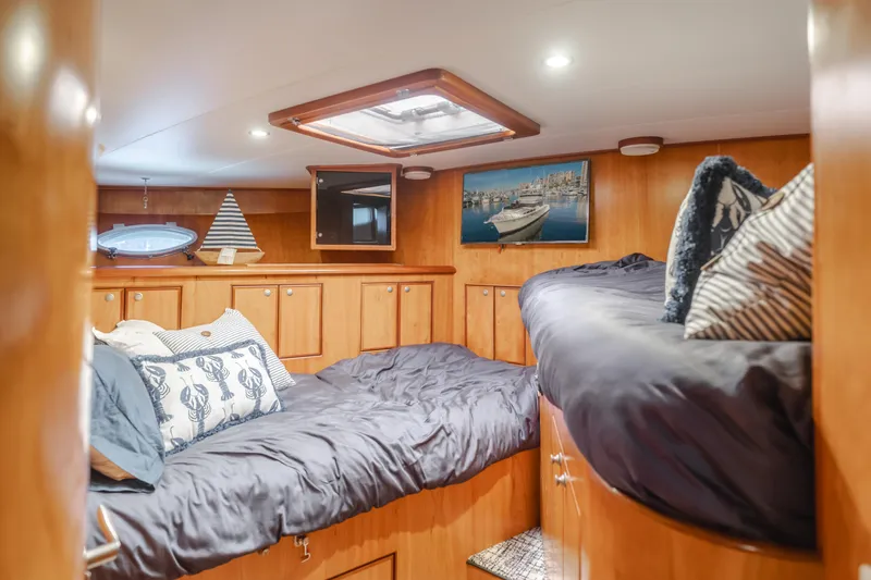 Tribeless Yacht Photos Pics Luxurious cabin interior of 2002 Mikelson 70 Sportfisher yacht with cozy bedding.