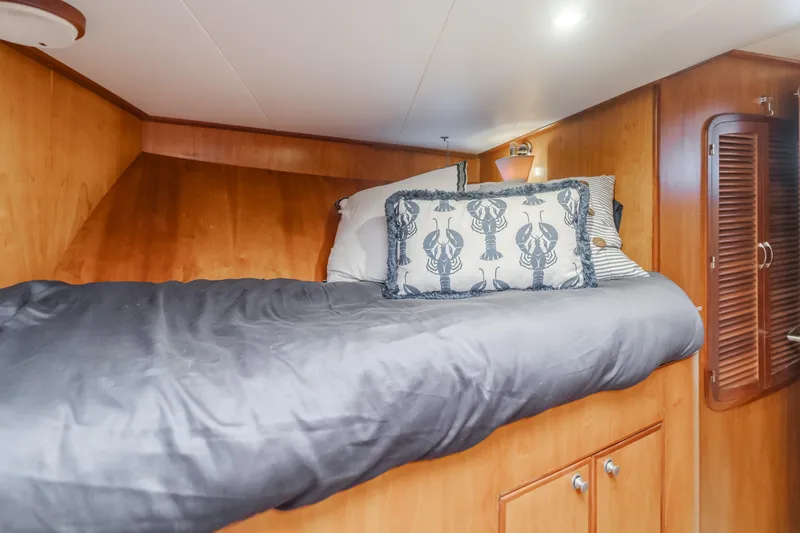 Tribeless Yacht Photos Pics Cozy cabin bed in 2002 Mikelson 70 Sportfisher yacht with nautical-themed pillows.