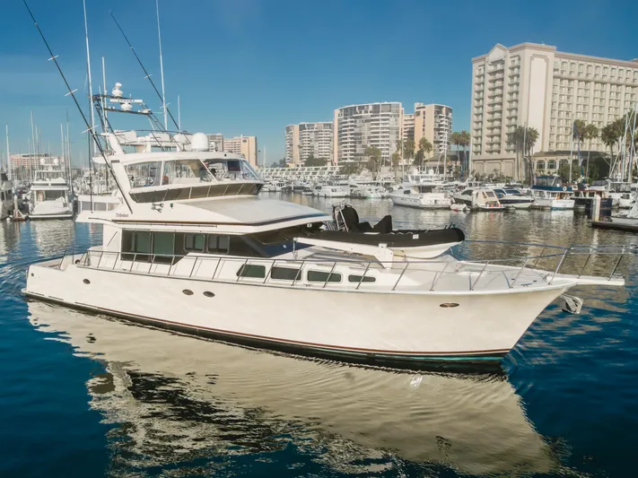Tribeless Yacht Photos Pics 2002 Mikelson 70 Sportfisher yacht docked in marina with cityscape background.