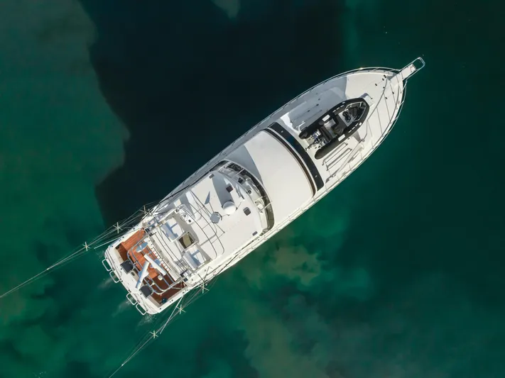 Tribeless Yacht Photos Pics Aerial view of 2002 Mikelson 70 Sportfisher yacht on clear water.