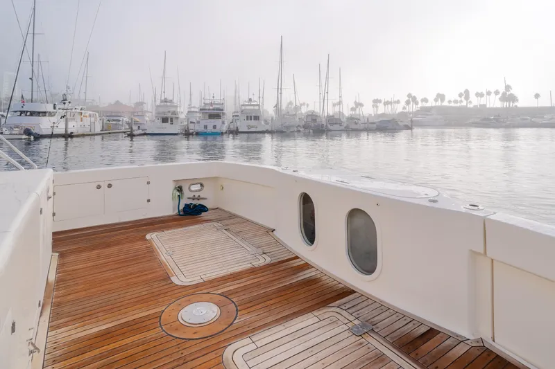 Tribeless Yacht Photos Pics Mikelson 70 Sportfisher 2002 yacht deck with marina view and wooden flooring.