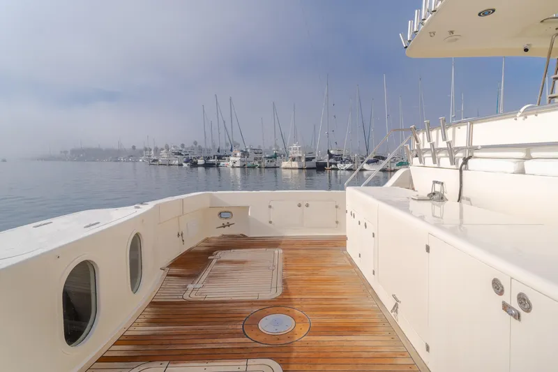 Tribeless Yacht Photos Pics Mikelson 70 Sportfisher 2002 yacht deck with marina view and wooden flooring.