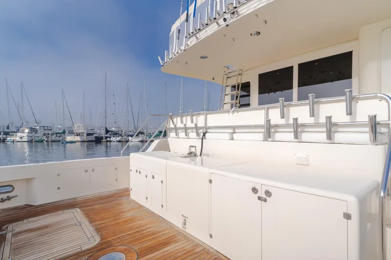 Tribeless Yacht Photos Pics 2002 Mikelson 70 Sportfisher yacht deck with rod holders and marina view.