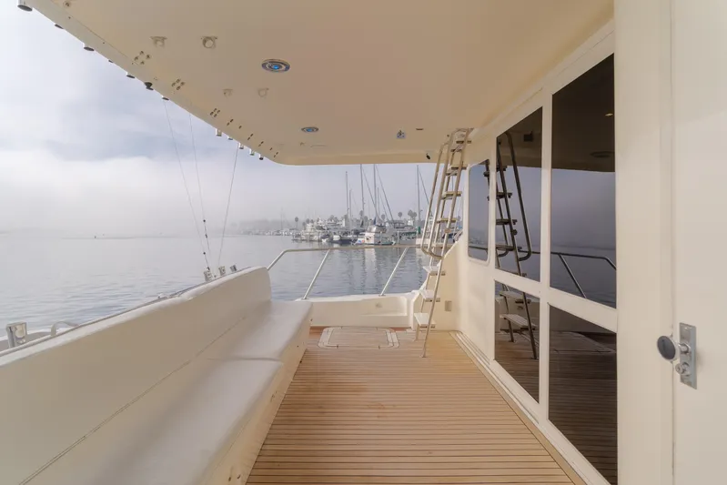 Tribeless Yacht Photos Pics Mikelson 70 Sportfisher 2002 yacht deck with seating, overlooking marina.