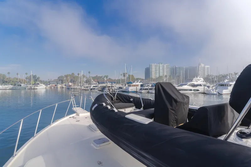 Tribeless Yacht Photos Pics Mikelson 70 Sportfisher 2002 yacht docked in a marina with cityscape background.