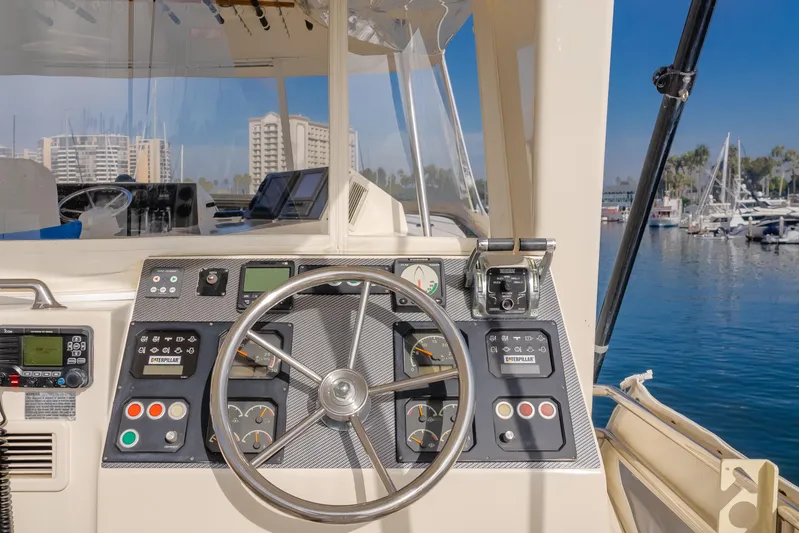 Tribeless Yacht Photos Pics Control panel of a 2002 Mikelson 70 Sportfisher yacht in a marina.