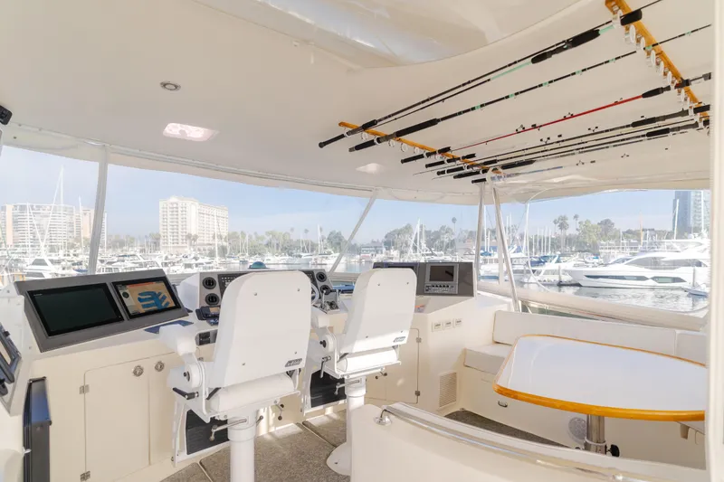 Tribeless Yacht Photos Pics Interior of 2002 Mikelson 70 Sportfisher yacht with fishing rods and navigation equipment.